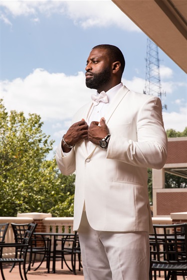 A groom in white on the patio